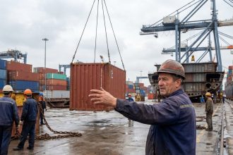 Ouvrier portuaire guidant un conteneur dans le port de Saint-Nazaire