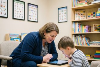Photo d'une therapiste avec un enfant dans une clinique moderne