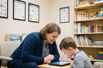 Photo d'une therapiste avec un enfant dans une clinique moderne
